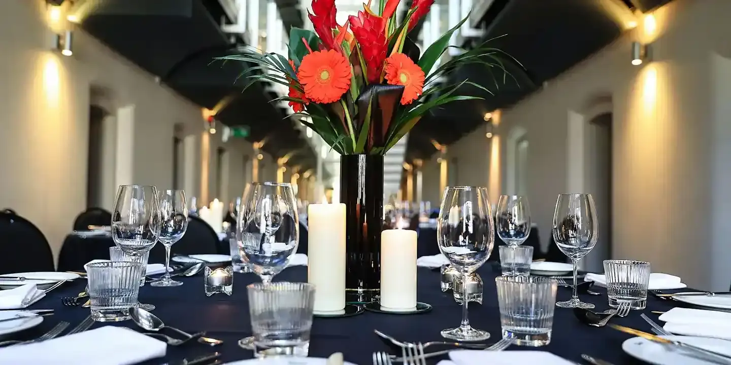 A table adorned with a vase filled with flowers and accompanied by flickering candles.