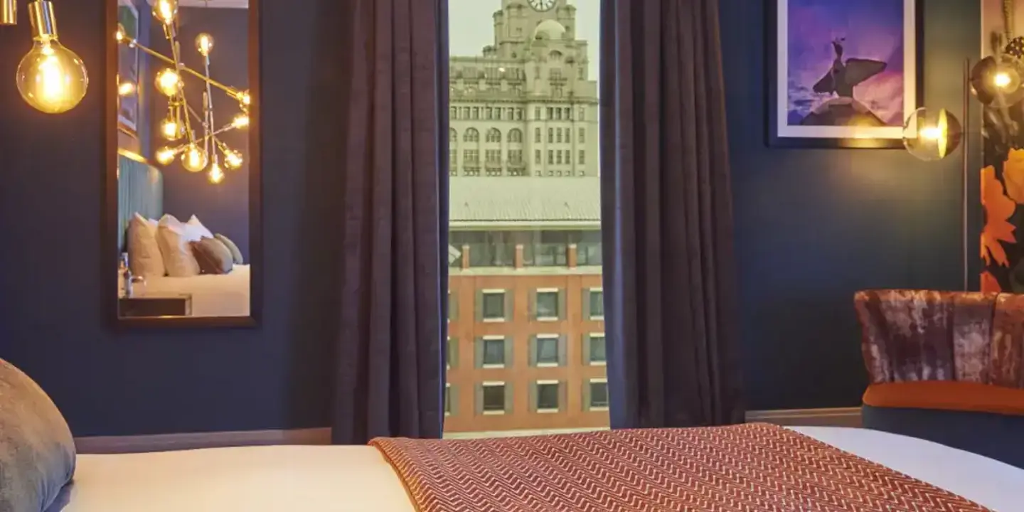 Spacious hotel room featuring a king-sized bed and panoramic city view.