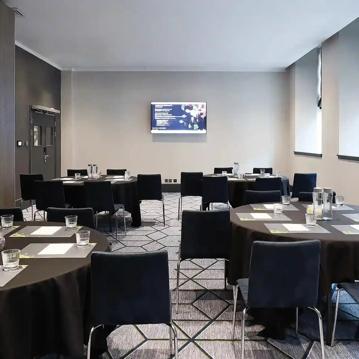 Conference room with neatly arranged tables and chairs.