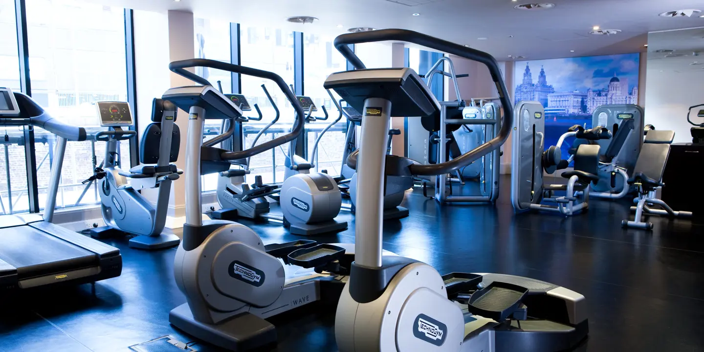Stationary exercise machines arranged in a gym.