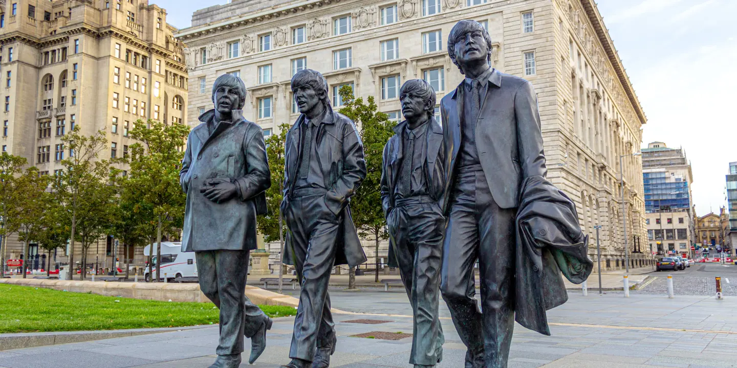 A statue of four men walking down the street.