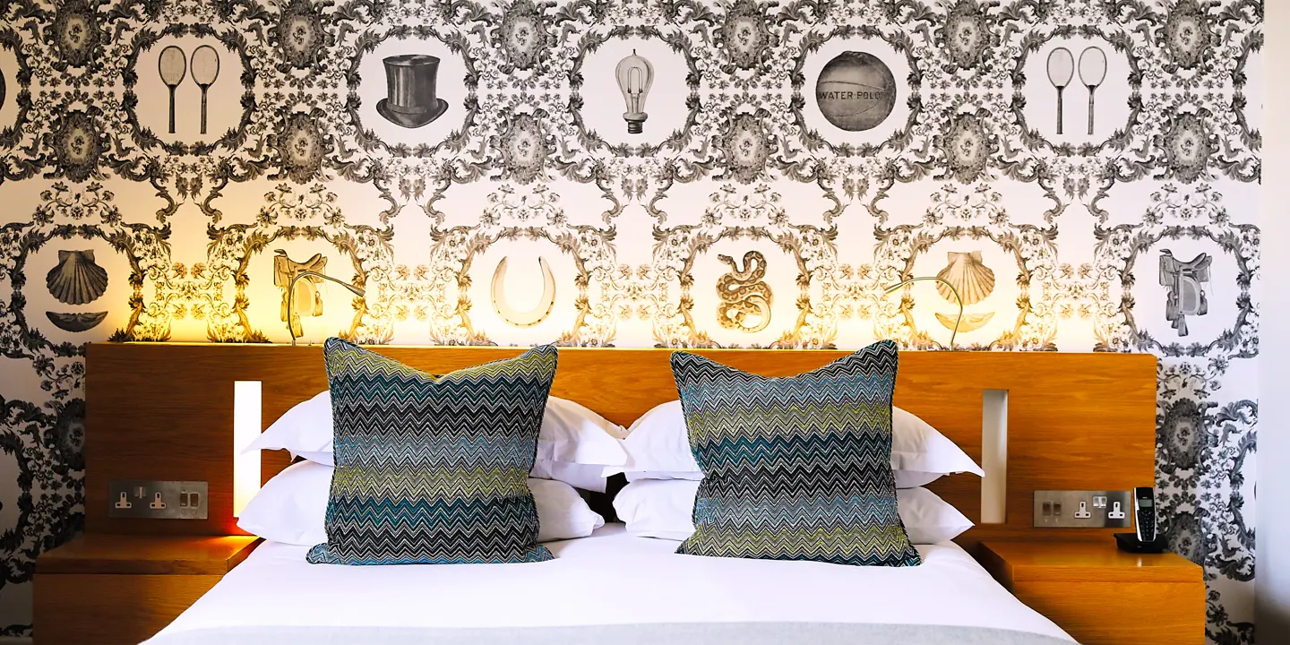 Bed with two patterned pillows placed on top.