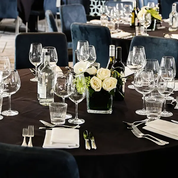 A table adorned with wine glasses and silverware is elegantly set.
