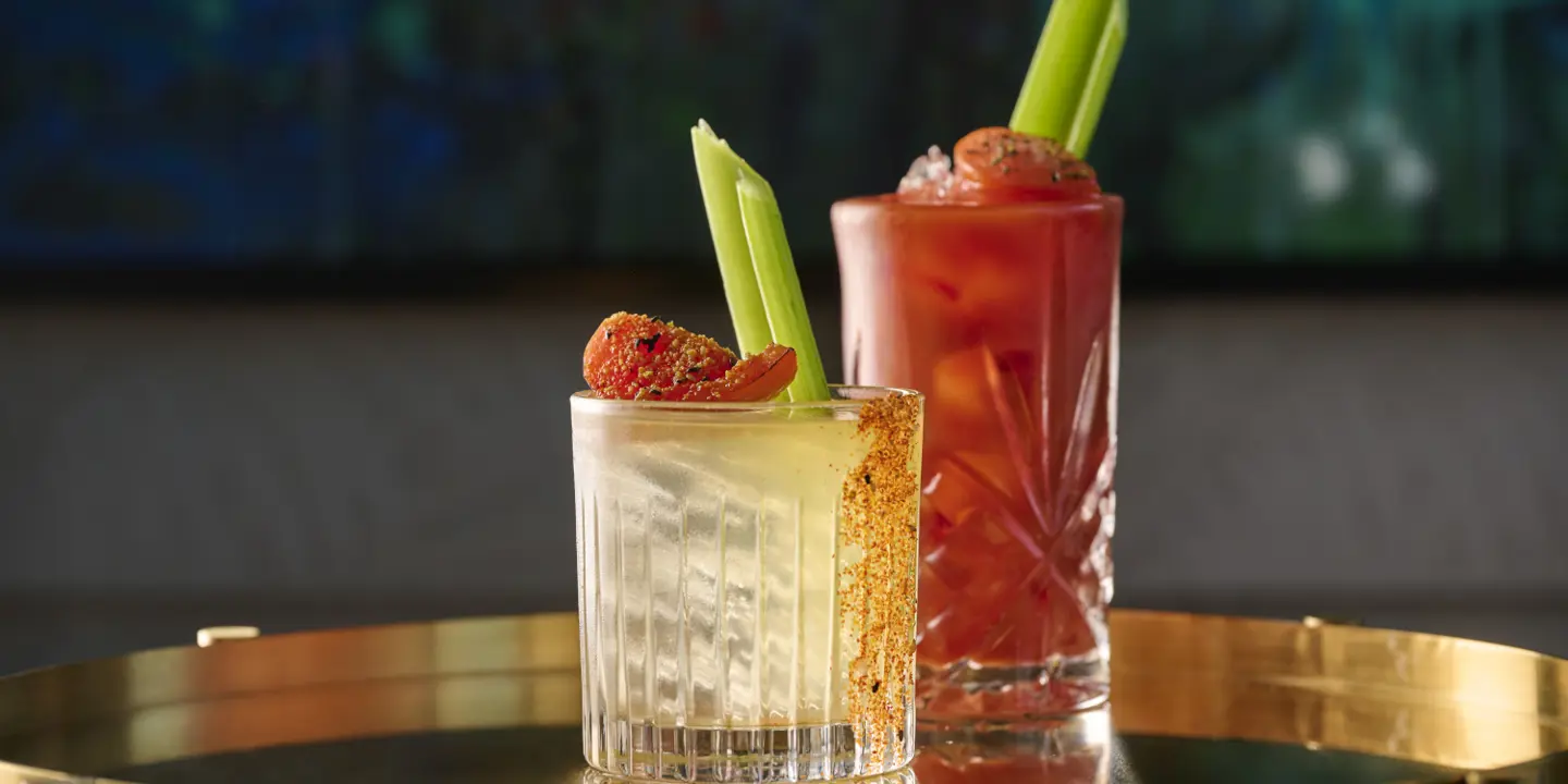 Two cocktail glasses placed on a table.