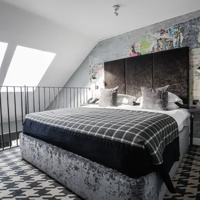 A bed positioned beneath a window adjacent to a wall.