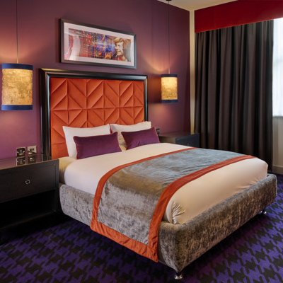 An elegantly designed bed with two plush pillows and an elegant headboard.