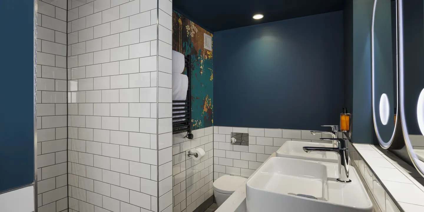 Bathroom featuring a toilet, sink, and shower stall.