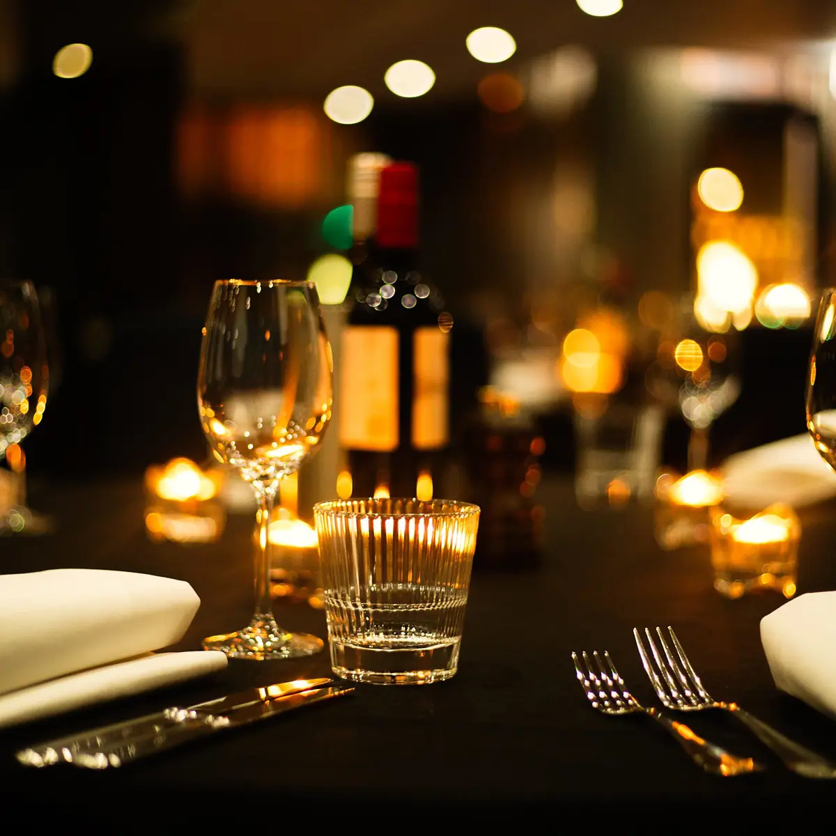 A beautifully arranged table adorned with elegant wine glasses and gleaming silverware.