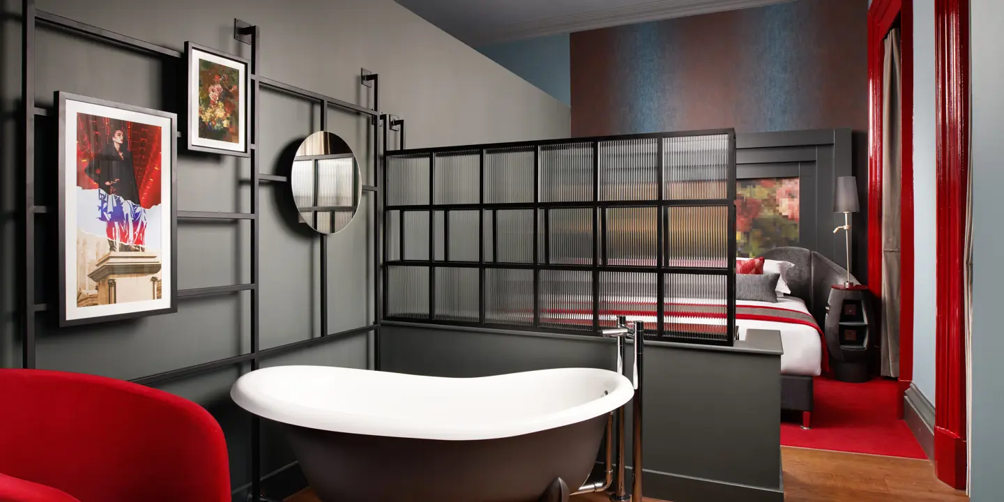 A room featuring a bathtub, chair, bed and wall decorations.