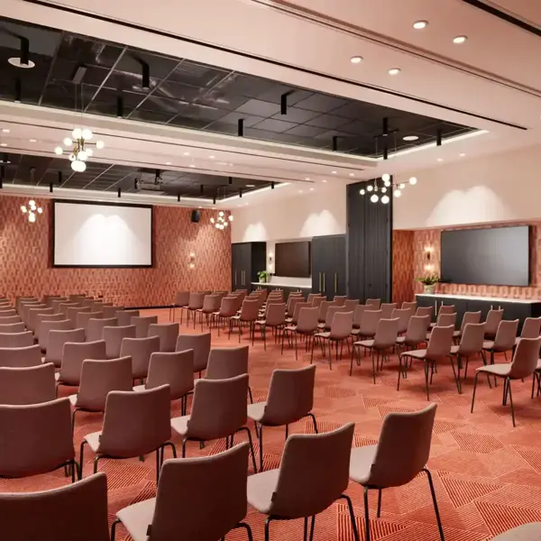 Conference room with neatly arranged rows of chairs and a large projector screen.