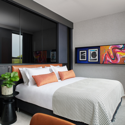 Bedroom featuring a bed adorned with orange cushions.