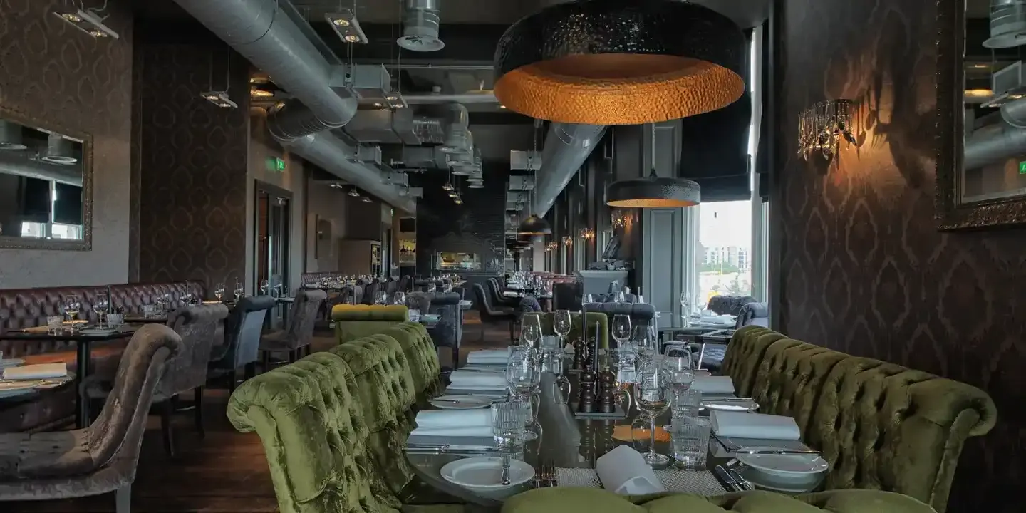 A dining room featuring a lengthy table adorned with green chairs.